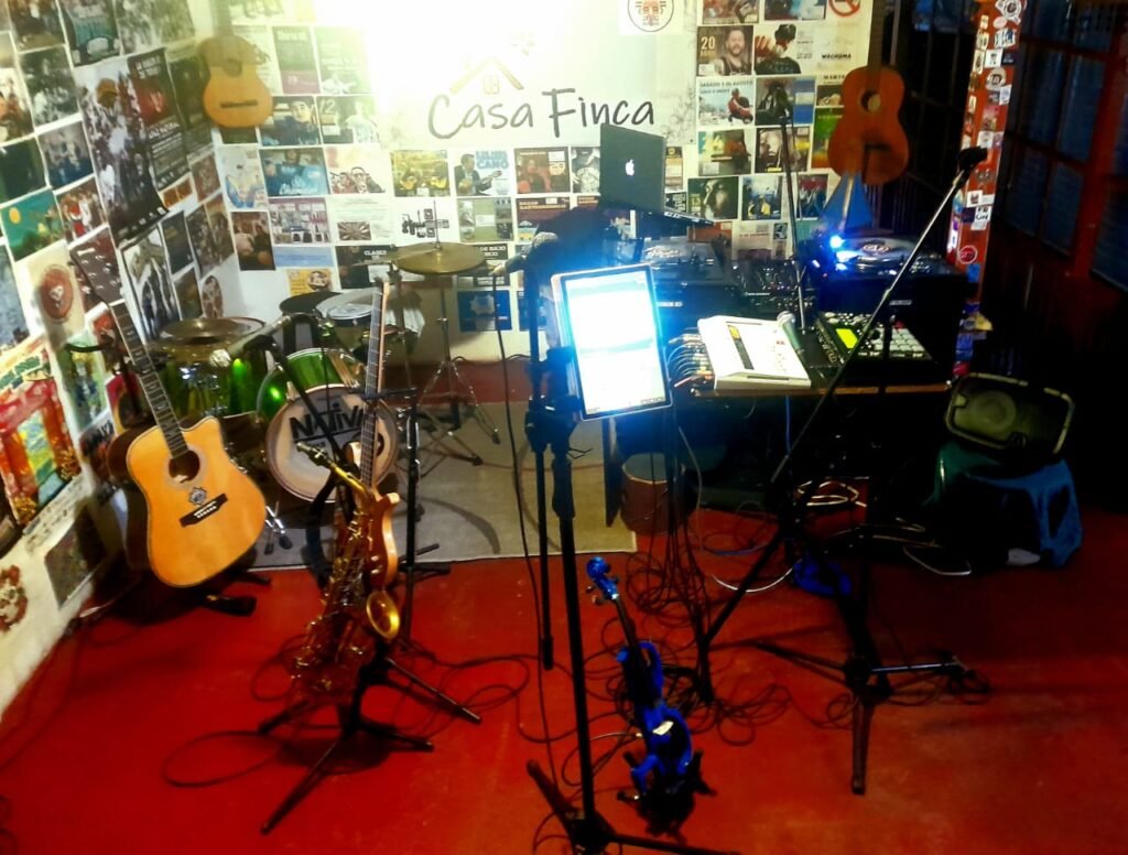 espacio de laboratorio musical con diversos instrumentos musicales y aparatos electronicos com mpc tornamesas y mezcladoras