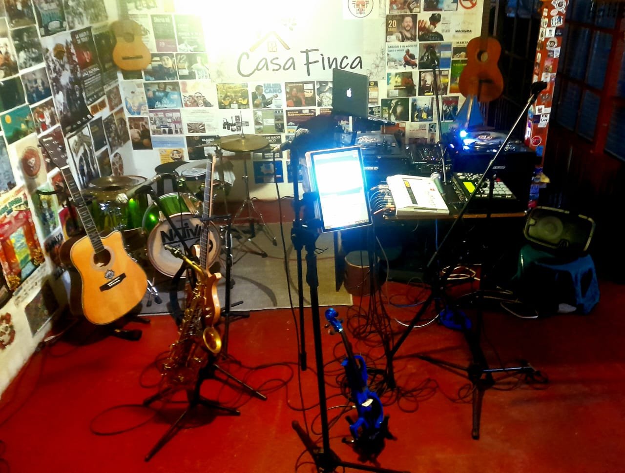 espacio de laboratorio musical con diversos instrumentos musicales y aparatos electronicos com mpc tornamesas y mezcladoras